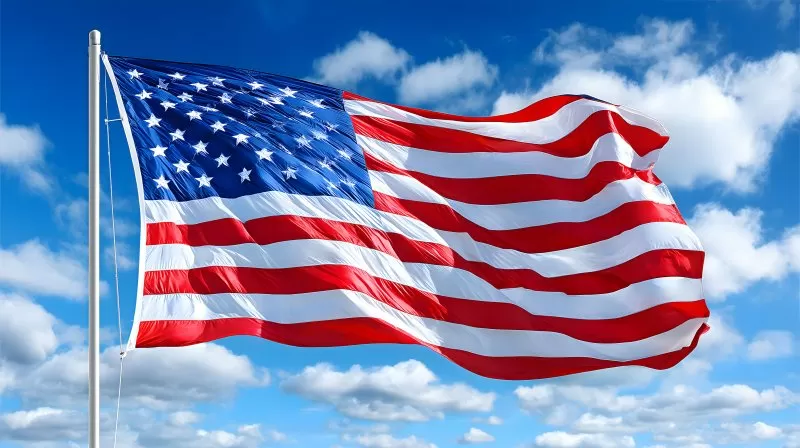 American flag waving in the wind under blue sky