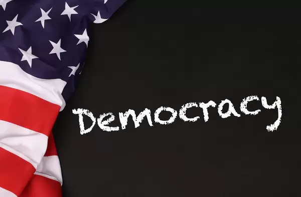 American flag with the text Democracy against a blackboard background