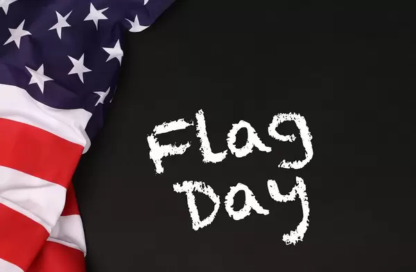 American flag with the text Flag day against a blackboard background