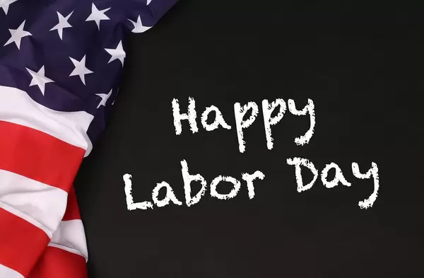 American flag with the text Happy Labor Day against a blackboard background