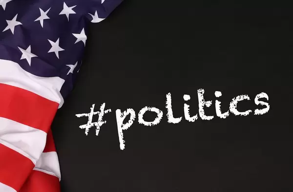American flag with the text #politics against a blackboard background.jpg