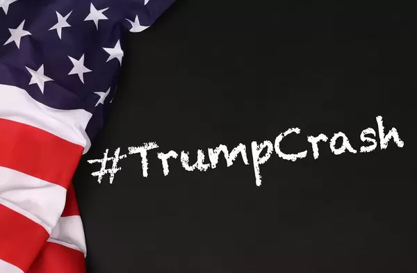 American flag with the text #TrumpCrash against a blackboard background
