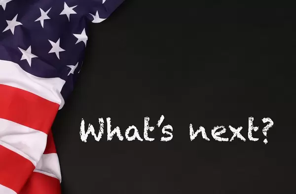 American flag with the text What's next? against a blackboard background.jpg