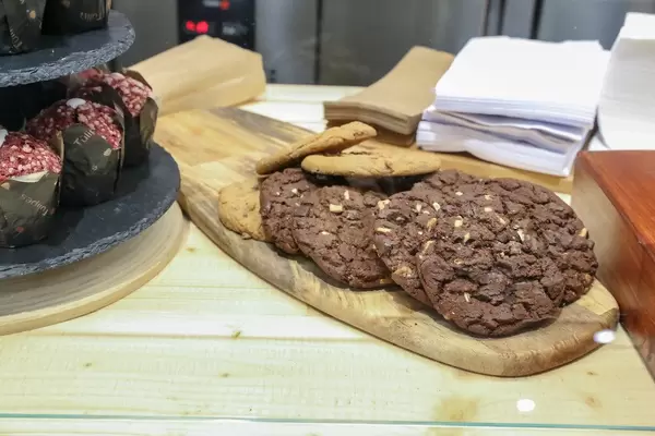 Amerikanische Cookies mit Schokolade und Muffin-Tulpen aus frischem Mett, in einem katalonischen Café am Camp Nou Stadion in Barcelona, Spanien