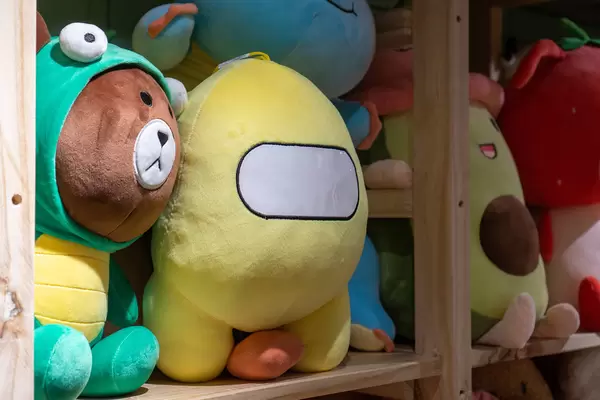 Among Us Theme Stuffed Animal among other Stuffed Toys in a Wooden Display Shelf at a Store