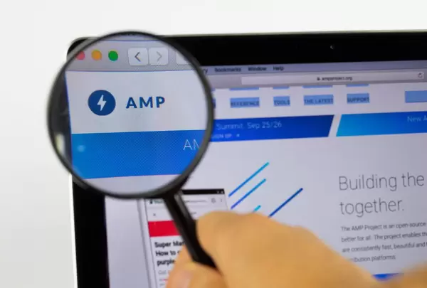 AMP-Logo am PC-Monitor, durch eine Lupe fotografiert