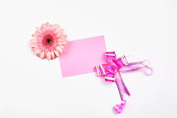 An empty greeting card decorated with ribbon and flower