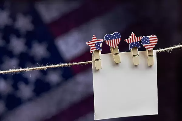 An empty paper card hanged with clothespin on the rope