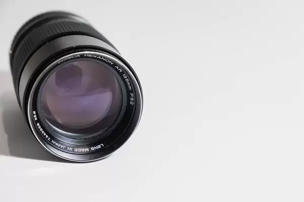 An old dusty camera lens on white surface.jpg