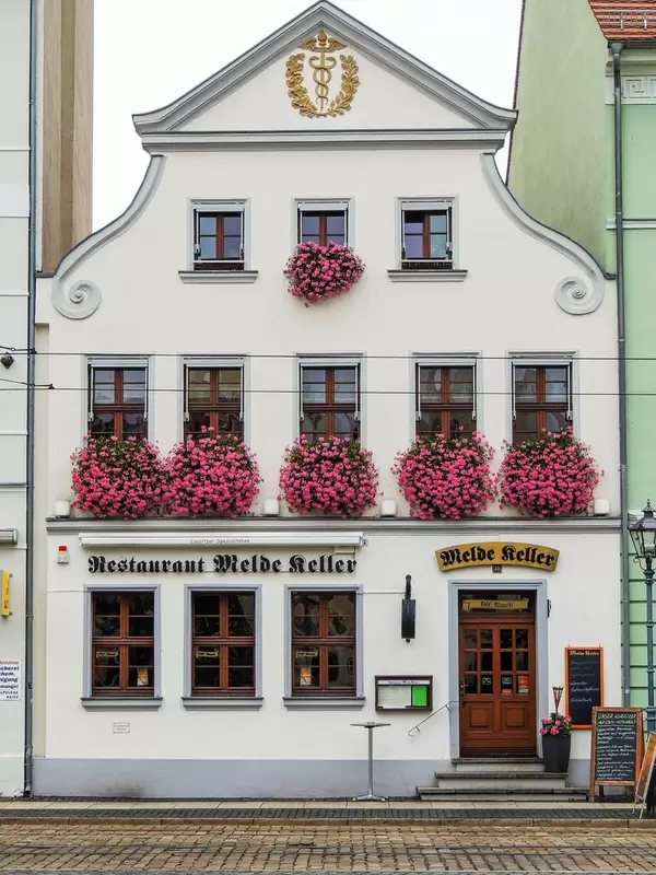 An old house with flowers on the window sills in the central square in Cottbus, Germany