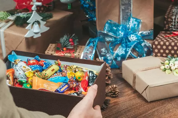An open box full of candy in a woman's hands