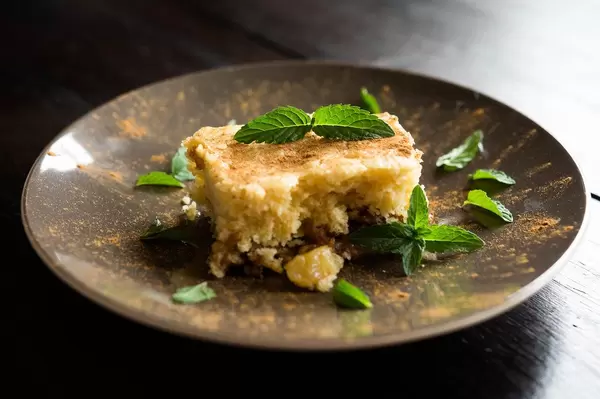 Ananas-Kaffee-Kuchen mit grünen Kräutern und Zimt dekoriert, auf einem kleinen Teller