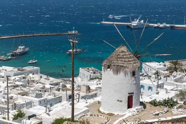 Ancient windmill, symbol of the Cyclades, overlooking Mykonos' main town Chora and harbour