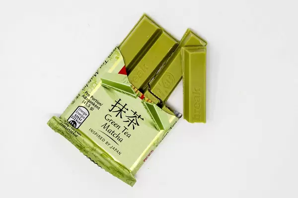 Angebrochene Schokoriegel in grüner Farbe und japanischem Grünen Matcha Tee Geschmack, isoliert auf weißen Untergrund