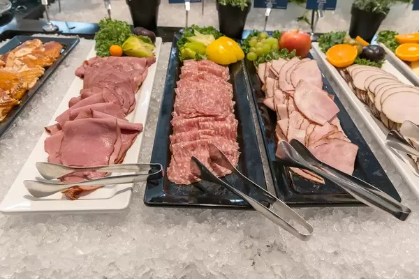 Angerichtete Wurstwaren am gekühlten Büfett mit Crushed-Ice und mit Obst und Gemüse dekoriert