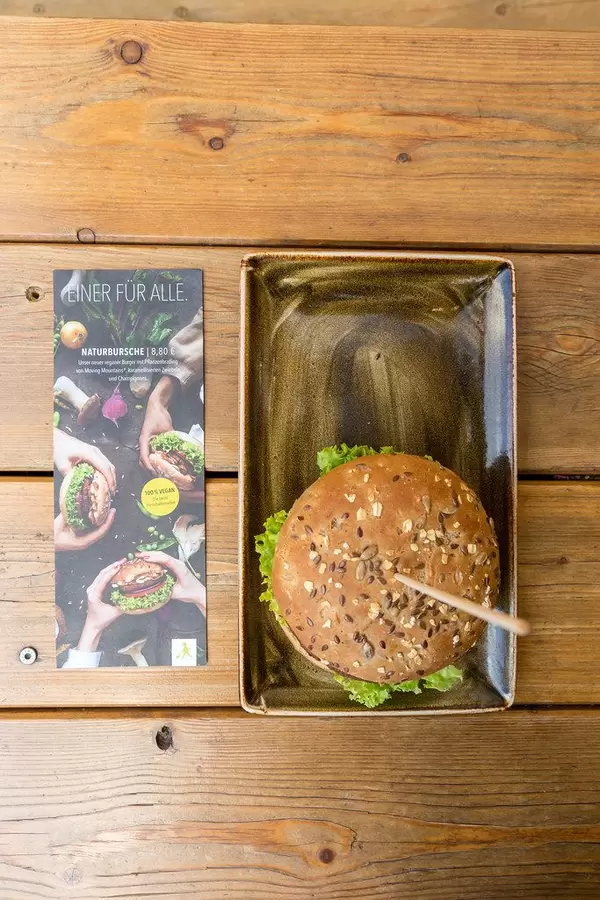 Ansicht von oben auf den neuen veganen Burger mit Pflanzenbratling von Moving Mountains mit karamellisierten Zwiebeln bei "Hans im Glück"