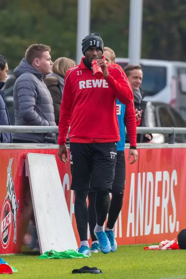 Anthony Modeste trinkt am Rande des Trainings unter Beobachtung von Horst Heldt, dem neuen Geschäftsführer