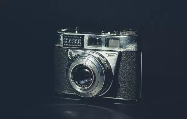 Antike Kamera mit Vintage-Look von Kodak mit integriertem Blitz vor schwarzem Hintergrund