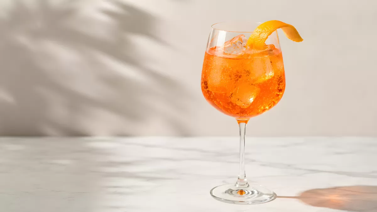 Aperol Spritz im Weinglas mit Orangenschale und Eis