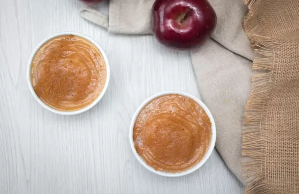 Apfelmus in Schälchen mit einem Apfel in der Aufsicht