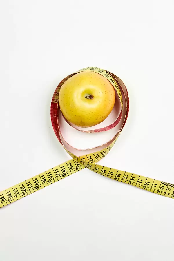 Apple and measuring tape on white. Dieting and healthy lifestyle concept