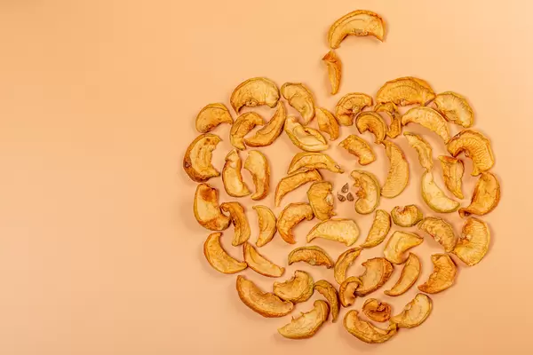 Apple made from pieces homemade dried apple on orange background