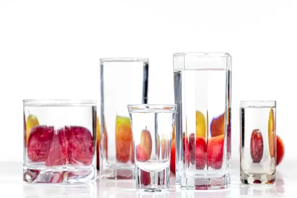Apples behind glasses of water