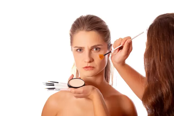 Applying powder to a woman's face