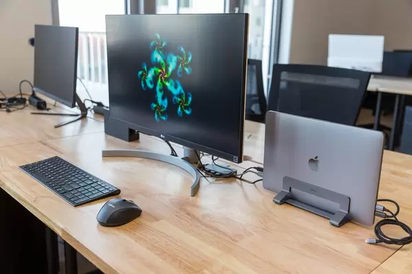 Arbeitsplatz am Schreibtisch im gemeinschaftlichen Arbeitsraum des WeWork Co-Working Space in Köln, mit LG-Bildschirm