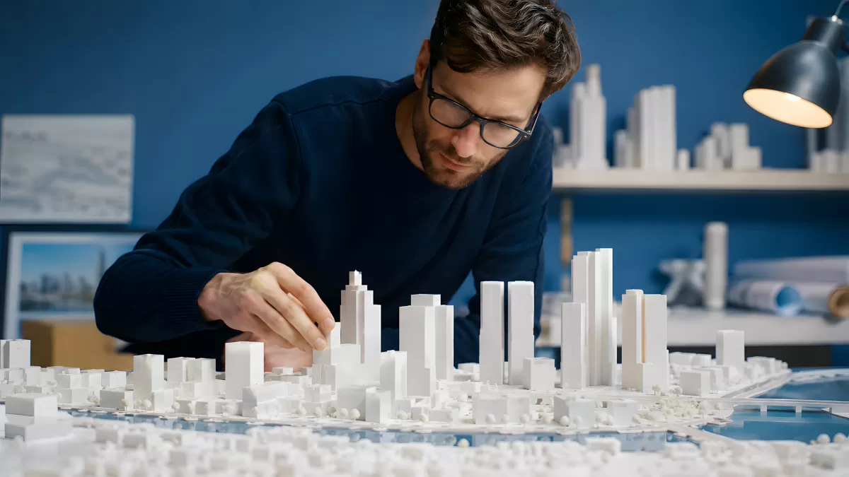 Architekt arbeitet an detailliertem Stadtmodell im Büro