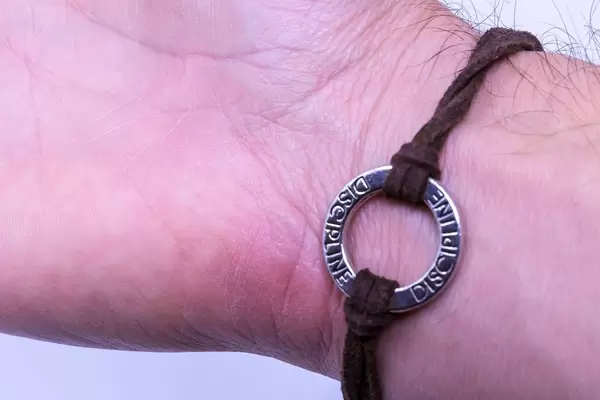 Armband aus Leder mit Medaillon und der Inschrift "Disziplin"