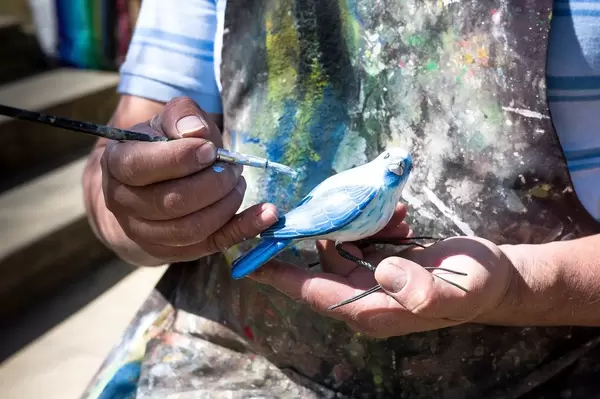 Artist painting ceramic bird
