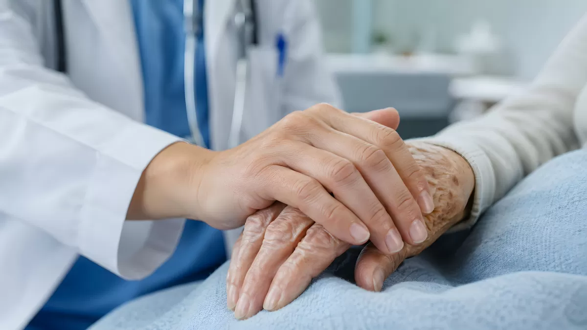 Arzt hält fürsorglich die Hand einer älteren Patientin