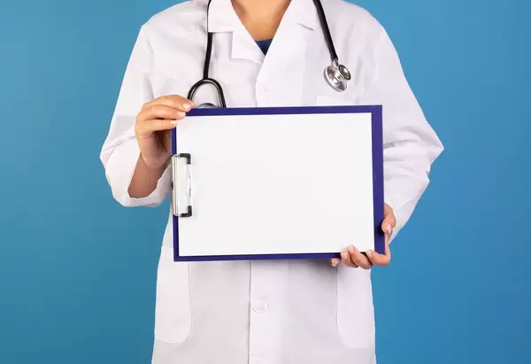 Arzt hält ein leeres Schild im blauen Hintergrund
