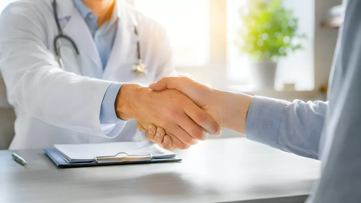 Arzt und Patient beim Händeschütteln in Praxis