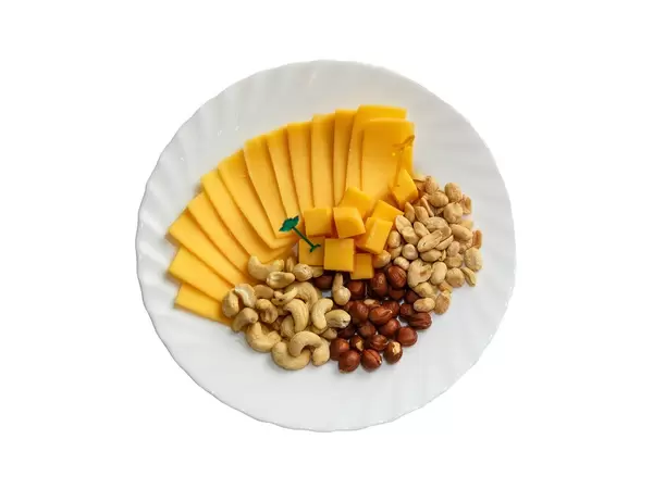 Assorted cheese and nuts in the plate on white background
