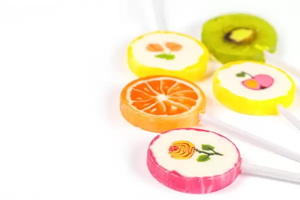 Assorted colors lollipops on white background, close-up