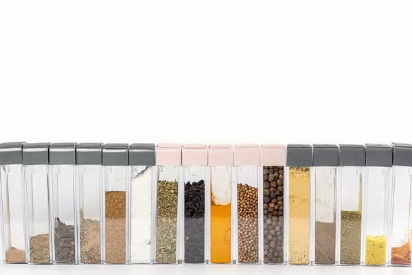 Assorted multi colored spices in boxes on white