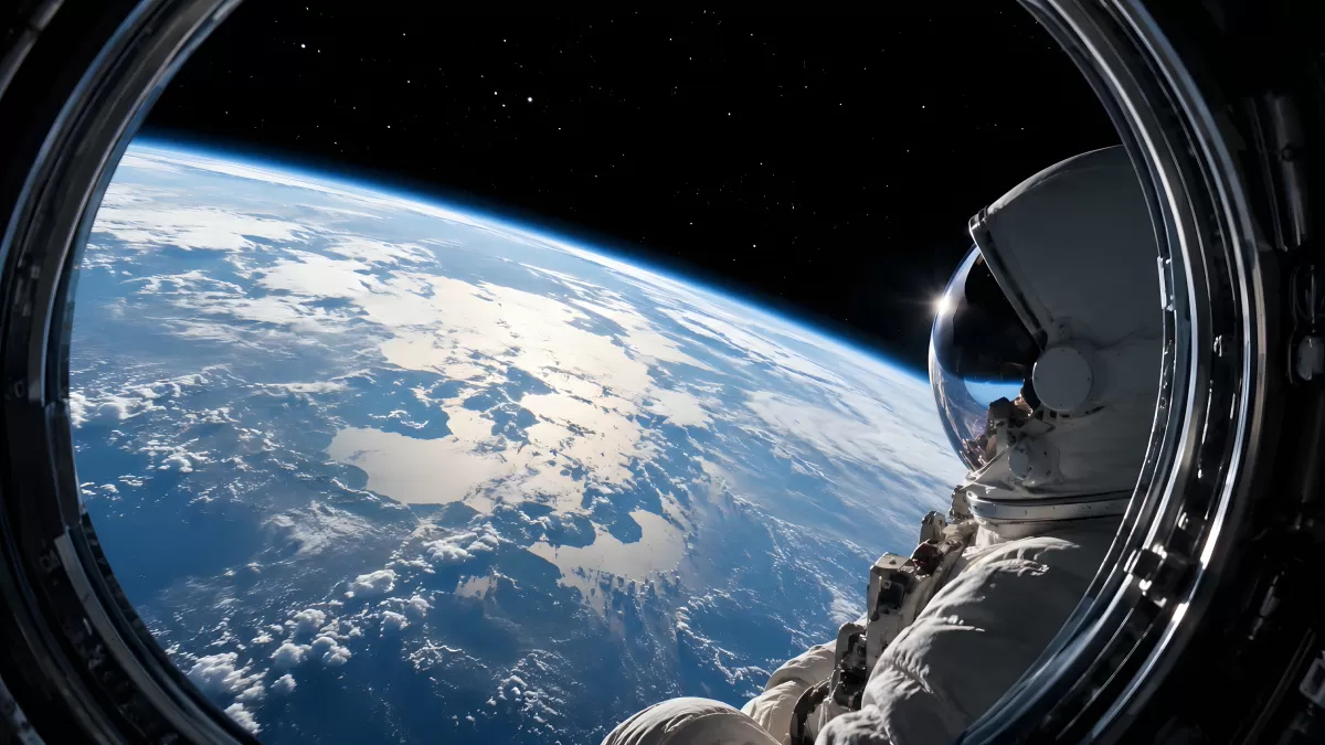 Astronaut blickt durch Bullauge auf die Erde aus dem All