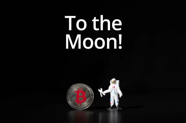 Astronaut mit silbernem Bitcoin und Text "To the Moon" (Zum Mond)