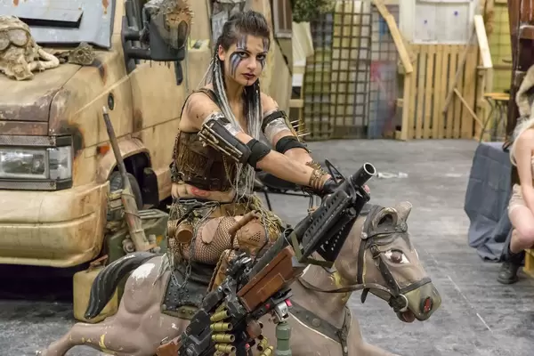 Attractive female cosplayer sitting on a merry go round horse