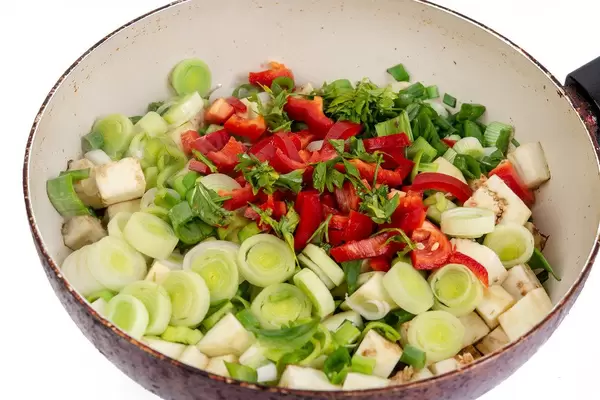 Auberginen, Lauch, Paprika und frische Kräuter in einer Pfanne