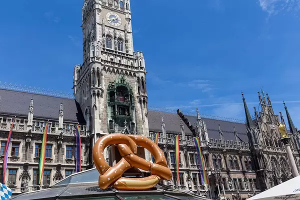 Aufblasbare Brezel am Brezelstand vor dem Neuen Rathaus mit gehissten Regenbogenflaggen während der CSD-Parade am Marienplatz