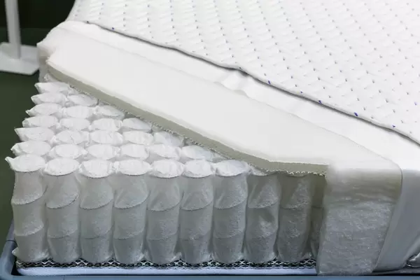Aufgeschnittene Matratze zeigt Aufbau mit Sprungfedern und Schaumstoff