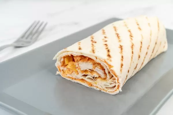 Aufgeschnittene Tortillarolle mit Gemüse und Hühnchenfleisch