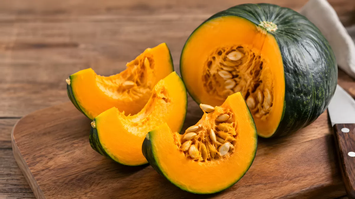 Aufgeschnittener Hokkaido-Kürbis auf Holzbrett