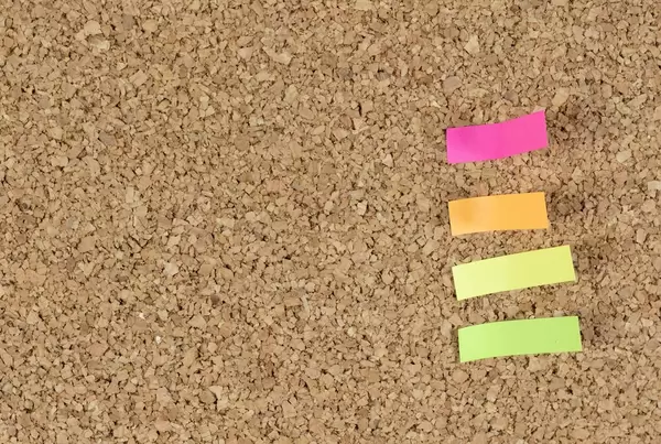 Aufkleber verschiedener Farben auf Tafel aus Kork