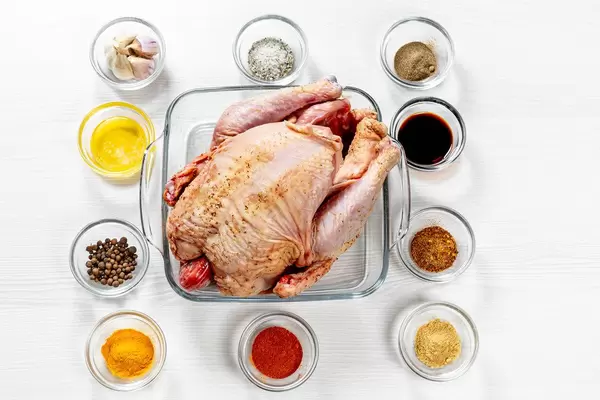 Aufnahme von oben: rohes Huhn mit Gewürzen, Saucen, Honig und Knoblauch. Zutaten für ein leckeres Rezept