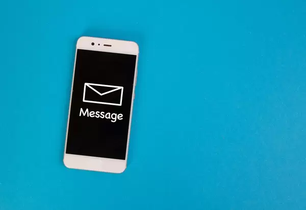 Aufschrift "Message" - Nachricht - mit einem Briefumschlag, auf dem schwarzen Display eines Smartphones