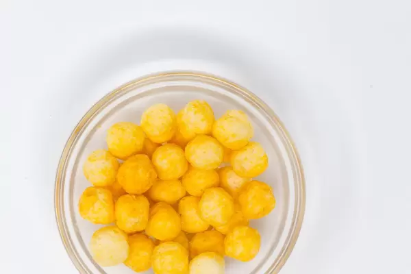 Aufsicht - ape - Vegane Kokosnuss und Reis Bällchen mit Käsegeschmack in Glasschale auf weißem Hintergrund